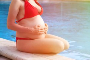 a-pregnant-woman-sitting-by-a-pool