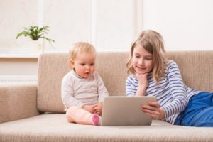 two-children-holding-a-tablet-for-video-chat